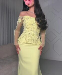 فستان أصفر فاتح مزين بتطريزات زهرية وأكمام شفافة