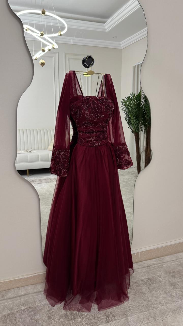 فستان سهرة عنابي مطرز بأكمام شفافة واسعة تصميم فخم وإطلالة ملكية