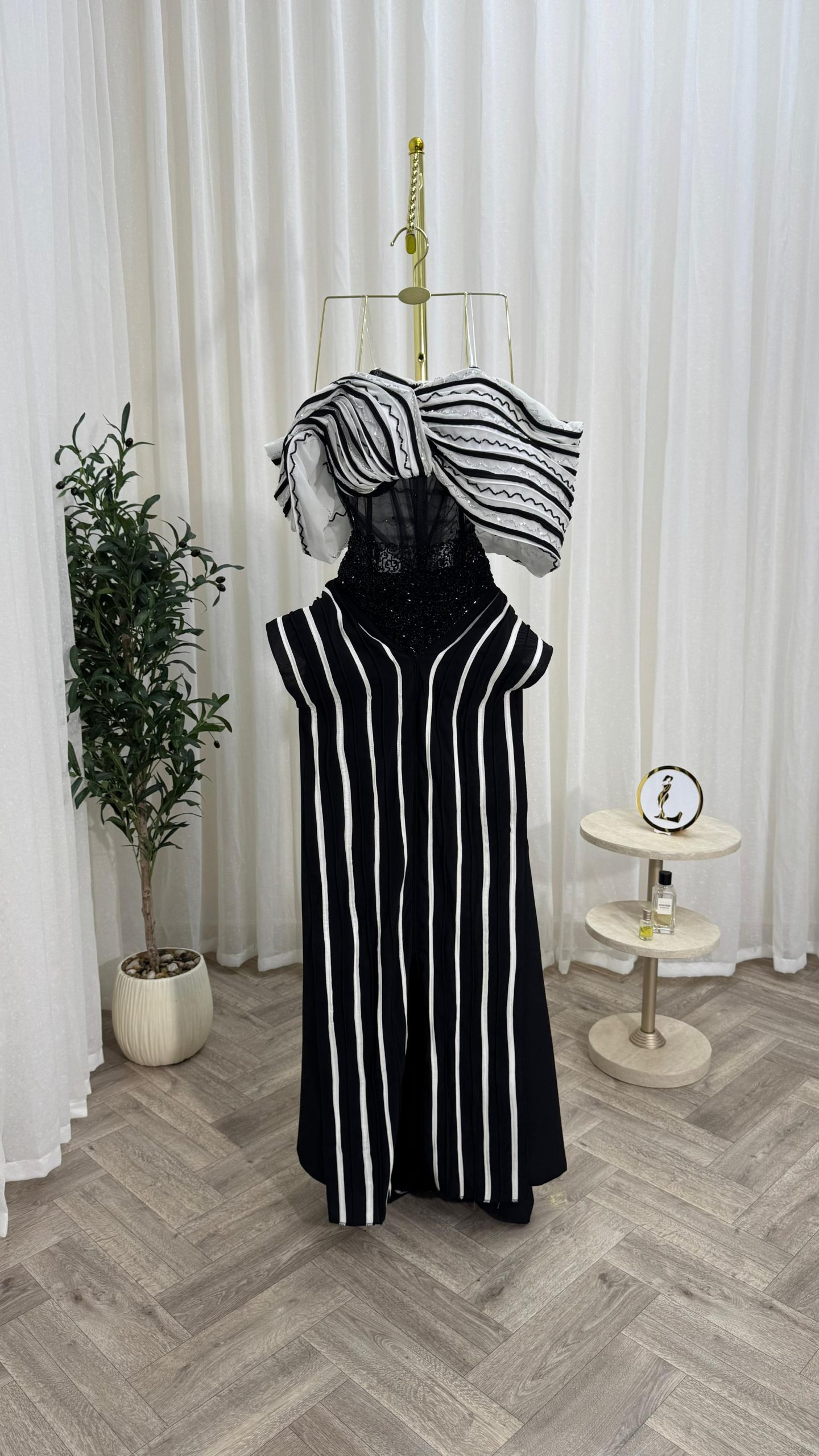 فستان سهرة أسود وأبيض بخطوط طولية وتصميم كتف درامي إطلالة فاخرة وعصرية - الصورة 4