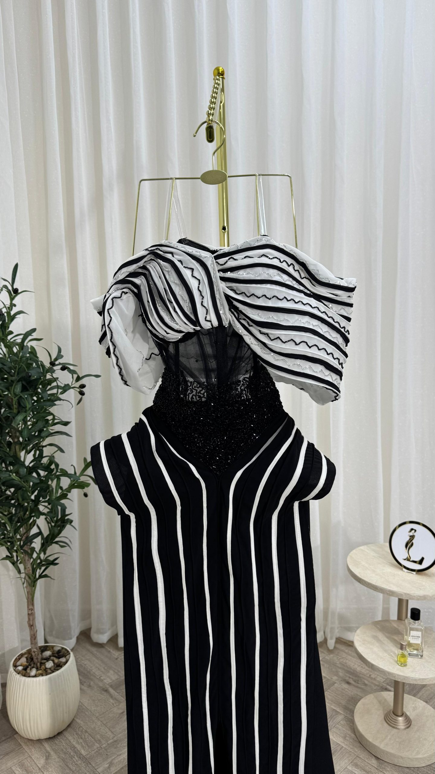 فستان سهرة أسود وأبيض بخطوط طولية وتصميم كتف درامي إطلالة فاخرة وعصرية - الصورة 7