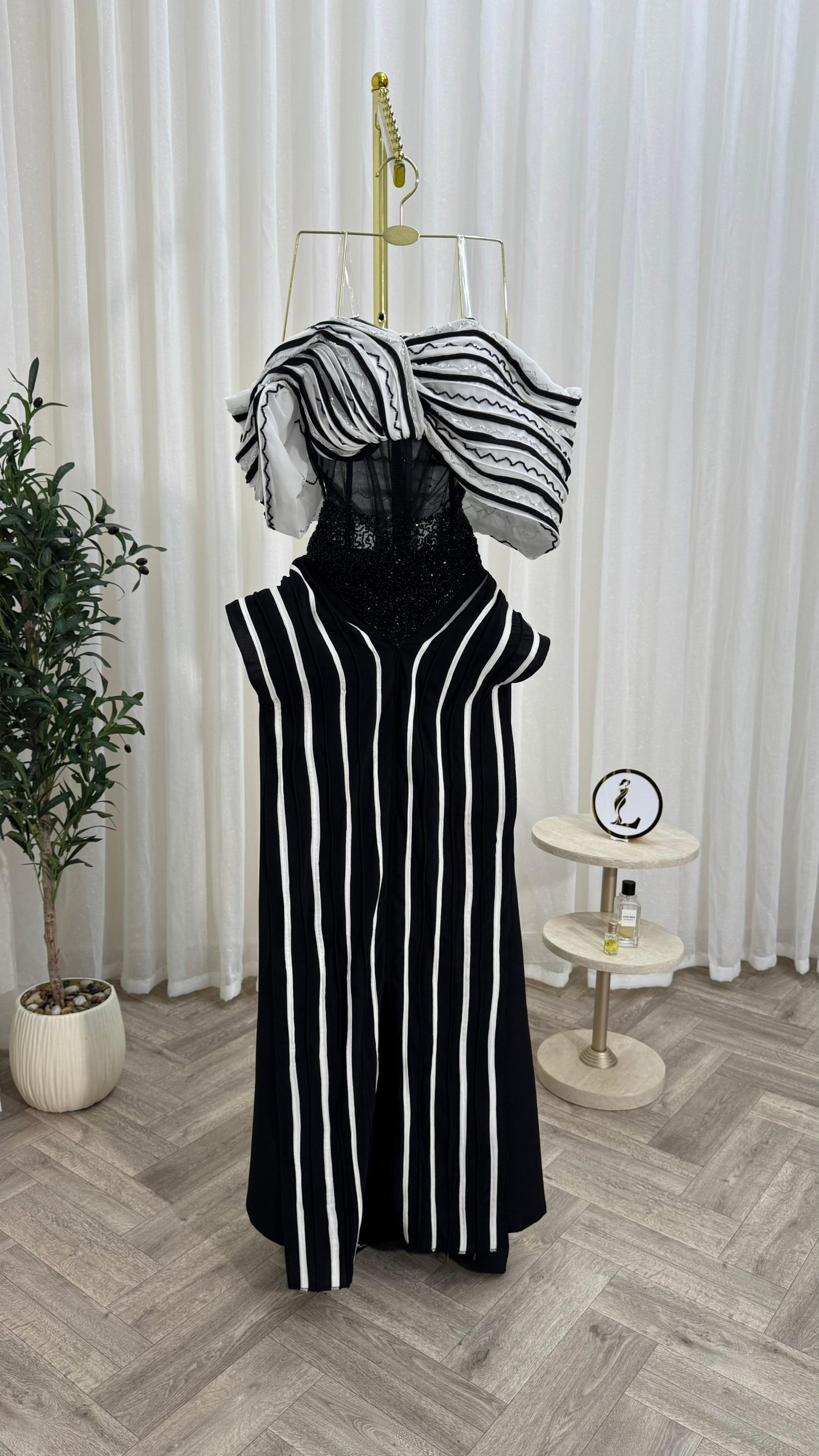 فستان سهرة أسود وأبيض بخطوط طولية وتصميم كتف درامي إطلالة فاخرة وعصرية - الصورة 5