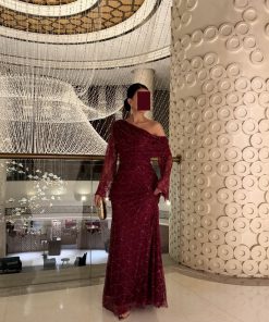 فستان سهرة عنابي لامع بتصميم كتف واحد وقصة أنيقة