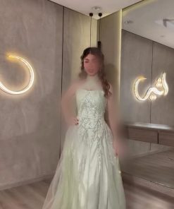 فستان سهرة أخضر فستقي بتصميم هالتر وتطريز راقٍ