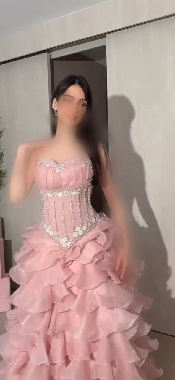 فستان سهرة وردي بتصميم كورسيه مرصع بالكريستال وتنورة طبقات كشكش واسعة
