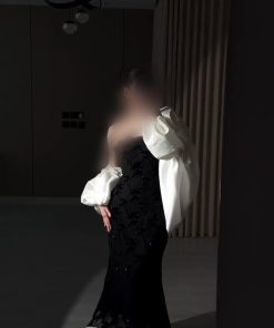فستان سهرة أسود طويل بتصميم منفوش وأكمام بيضاء بارزة