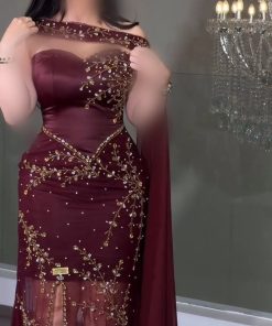 فستان سهرة عنابي بتصميم كيب وتطريز ذهبي فاخر