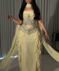 فستان سهرة أصفر فاتح بتصميم كاب وكشكش جانبي مرصع بالكريستال