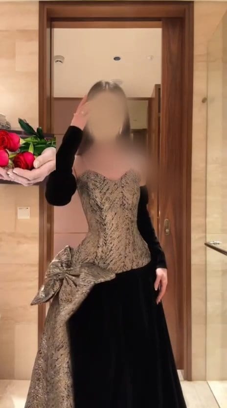 فستان سهرة طويل مزيج قماش جاكار ذهبي وجوخ أسود بياقة كب وفيونكة جانبية
