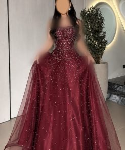 فستان سهرة عنابي طويل كب منفوش بكورسيه مرصع بحبات اللؤلؤ والترتر البراق